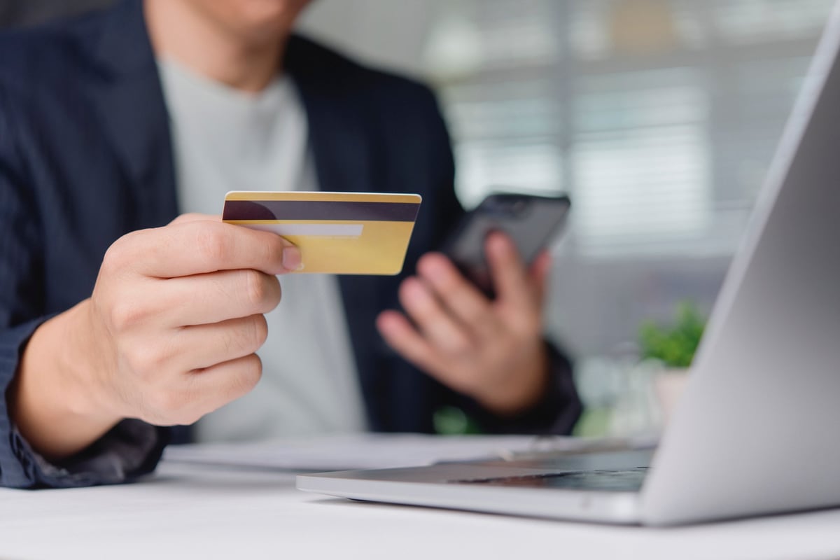 Customer verifying online transaction with credit card and smartphone